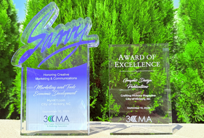 City of Hickory's two Savvy Awards sit in front of green bushes outside City Hall