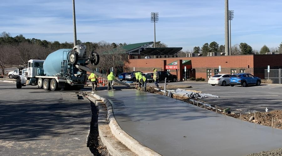 concrete being poured for the Aviation Walk in front of LP Frans Stadium